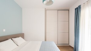 A bedroom with a bed, a wardrobe, and a window with curtains. - Acropolis - historical attractions walking distance (Athina)