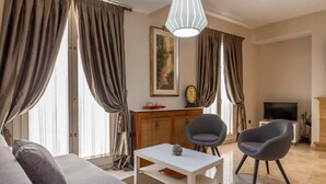 A modern living room with a sofa, two armchairs, a coffee table, and a TV. - Duplex penthouse with 70 m terrace (Sevilla)