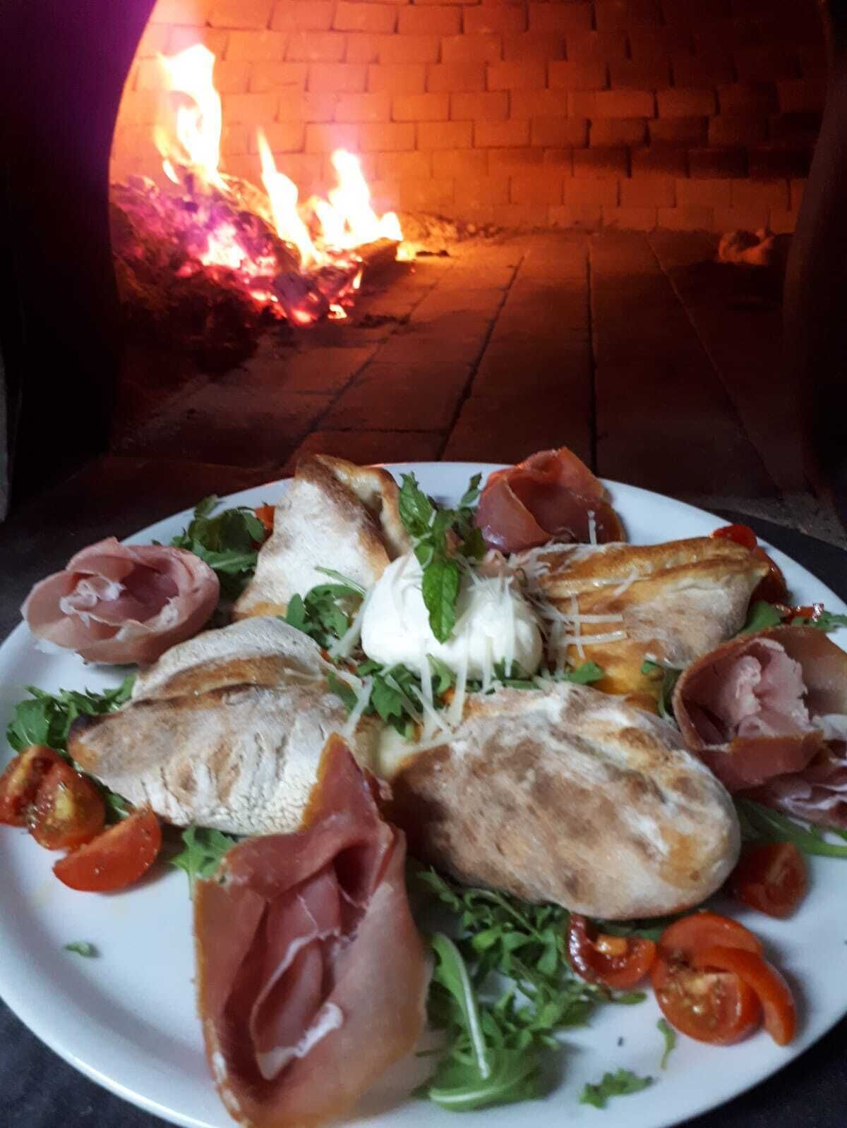 A pizza oven with a brick interior and a fire burning inside.