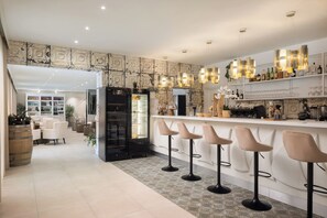 A modern kitchen with a bar area, bar stools, and a refrigerator.