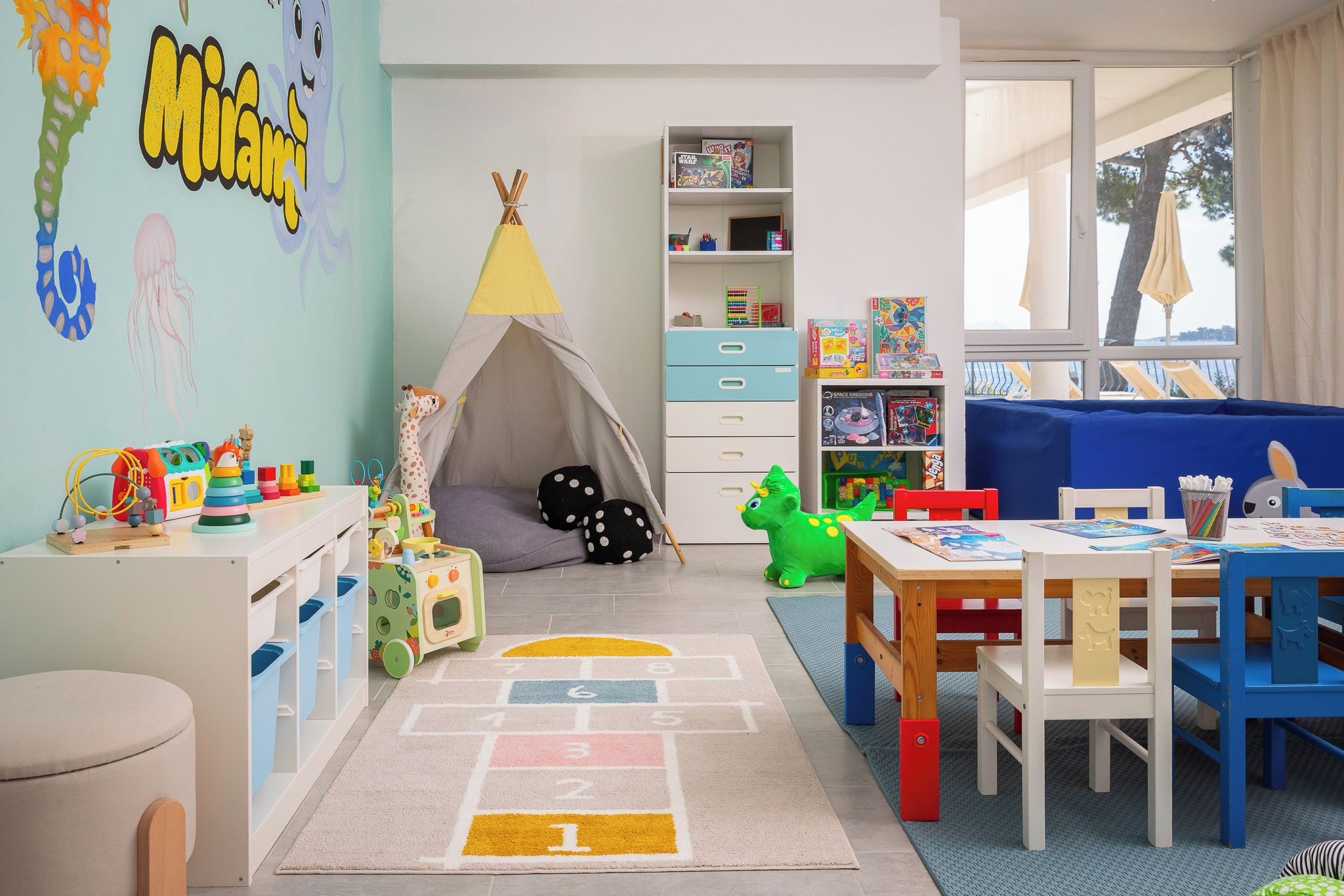 A child's playroom with a tent, toys, and a bookshelf.
