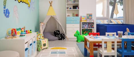A child's playroom with a tent, toys, and a bookshelf.