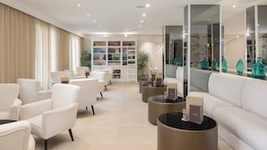 A modern lounge area with white sofas, a bookshelf, and decorative vases. - Bellevue Maradiso Village by Aminess (Orebic)