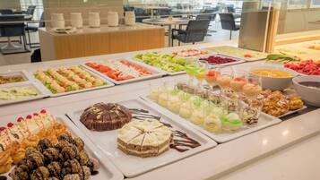 A buffet with various food options including salads, desserts, and beverages.