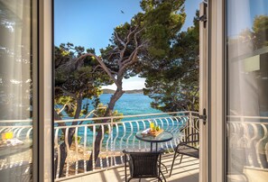A balcony with a clear view of the sea, a table with a tray of food, and a chair. - Bellevue Maradiso Village by Aminess (Orebic)