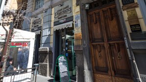 Un edificio histórico con detalles arquitectónicos ornamentales, que incluyen una entrada imponente y múltiples ventanas.