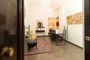 A modern hotel lobby with a reception desk, seating area, and artwork on the walls.