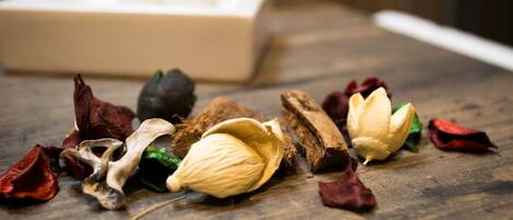 A wooden table with dried flowers, a coconut, and a small plant in the background.