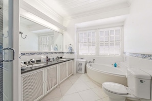 A bathroom with a bathtub, toilet, and sink.