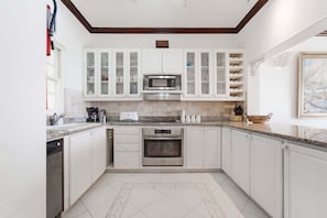 A modern kitchen with white cabinets, a microwave, an oven, and a dishwasher.