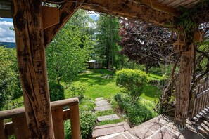 A wooden pergola with a stone staircase leading to a lush garden.