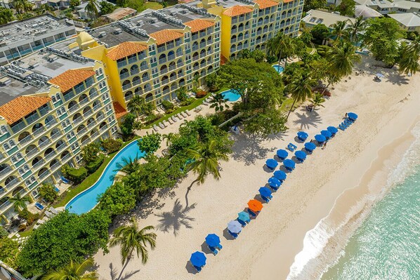 Un resort con piscina, playa y varios balcones.