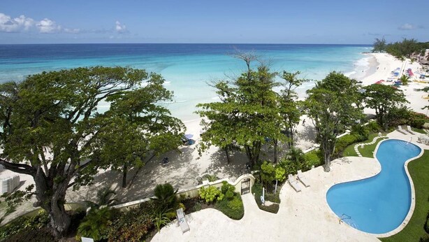 Un complexe hôtelier doté d’une plage, d’une piscine et d’une végétation luxuriante.