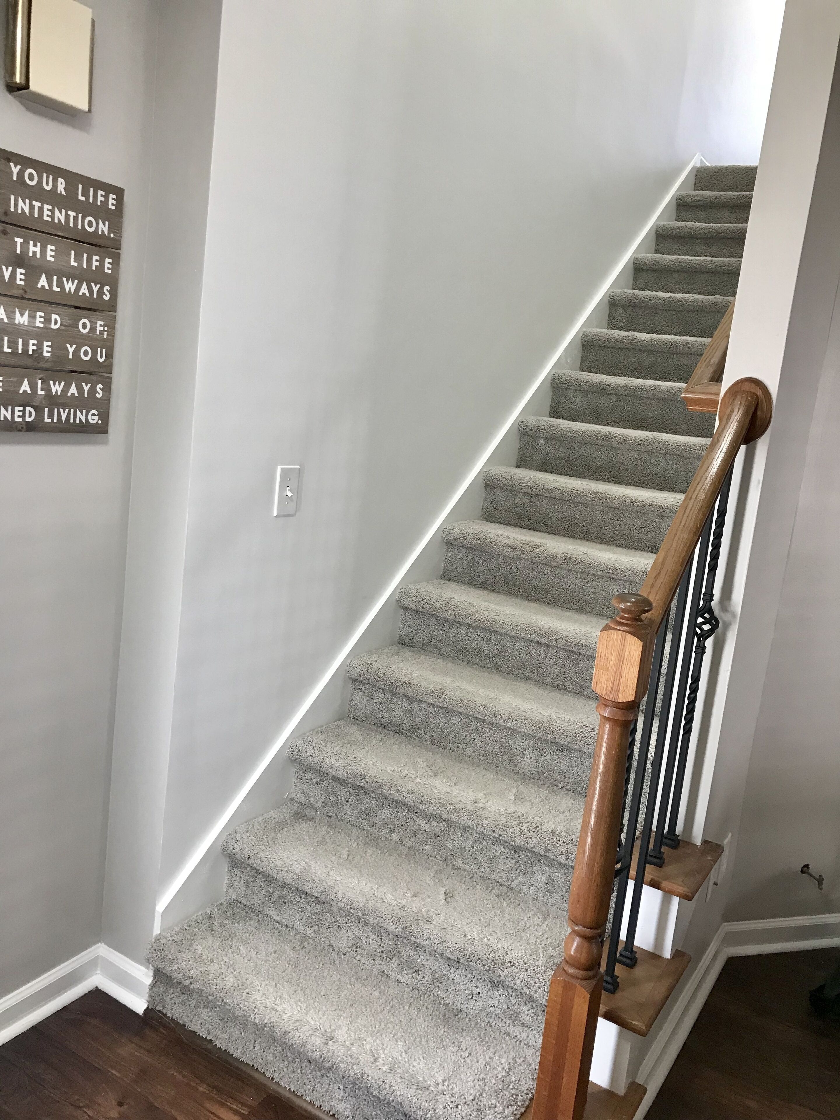 Una escalera con escalones alfombrados y barandilla de madera.