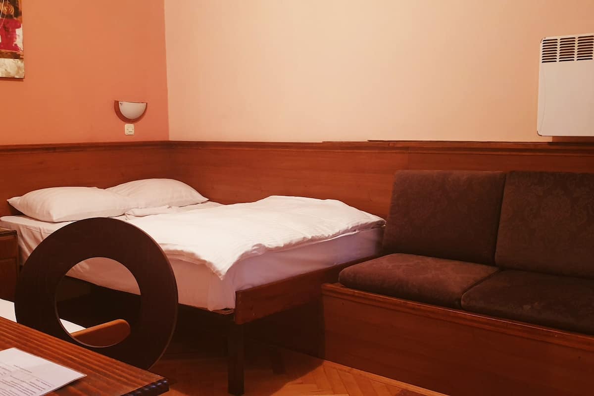 Un dormitorio con una cama, una mesita de noche, un escritorio y una silla.
