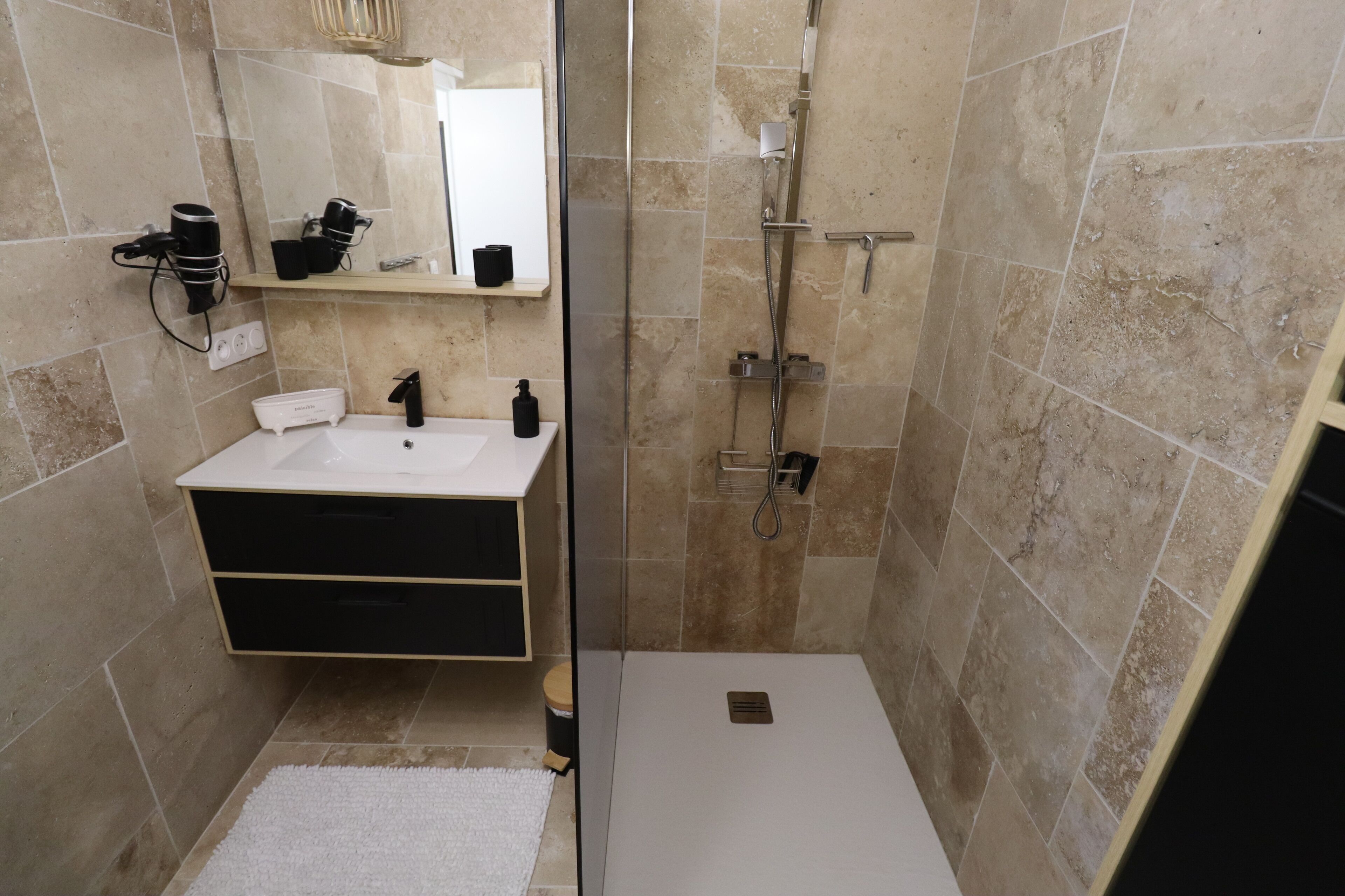 Un baño con lavabo, espejo y ducha.