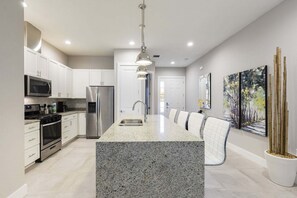 A modern kitchen with granite countertops, stainless steel appliances, and a central island.