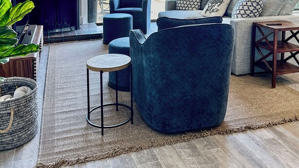 Un salon moderne doté d’une grande fenêtre donnant sur un port de plaisance.