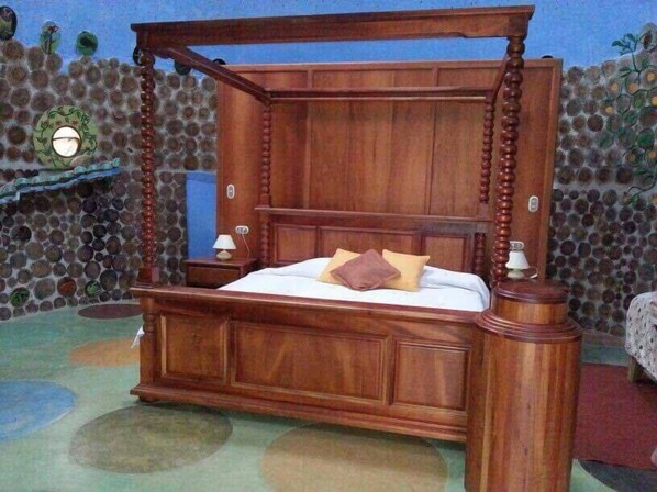 Una cama con dosel y estructura de madera, con un cabecero.
