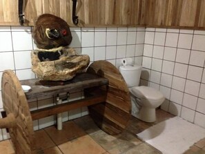 Un baño con tocador de madera, inodoro y lavamanos.