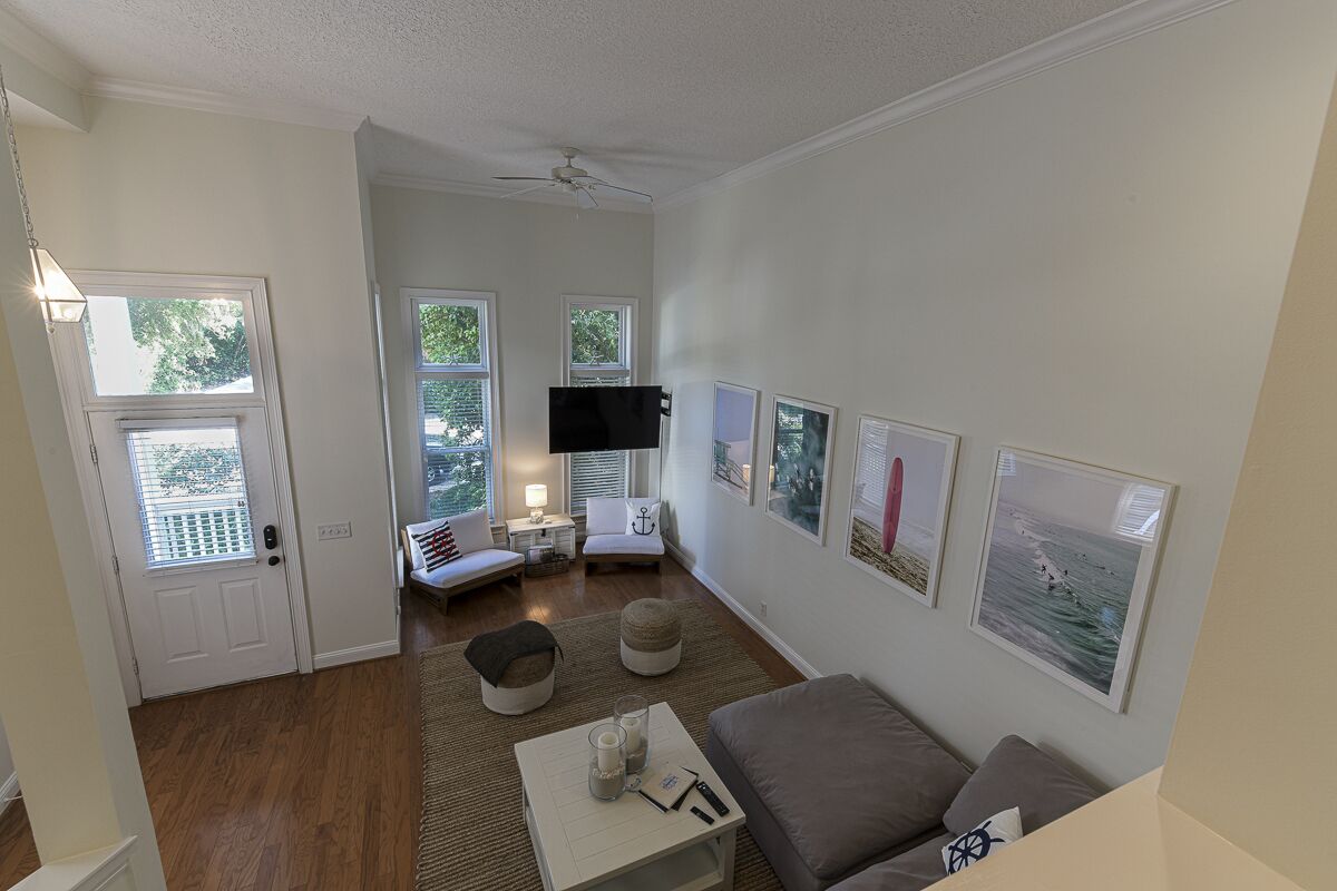 A living room with a sofa, a coffee table, a TV, and framed pictures on the wall.