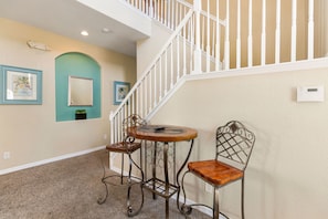 A staircase with white balusters and a beige wall with two framed pictures.