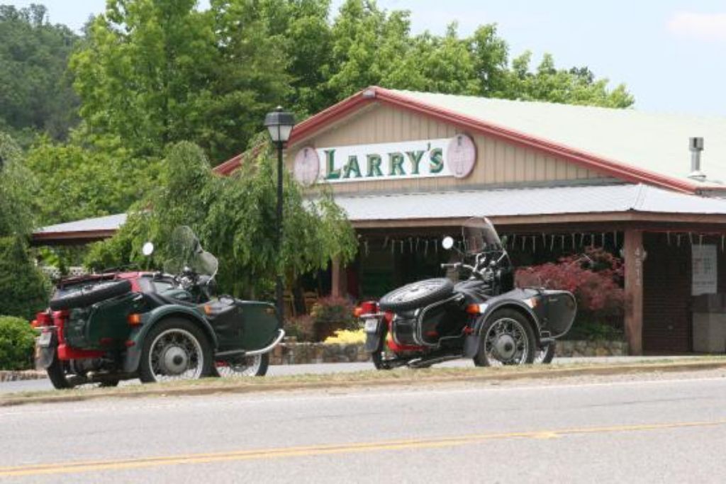 A building with a sign reading "Larry's" and two motorcycles parked in front.