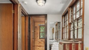 A wooden hallway with a bench, a door, and a window with a view of the outdoors. - MOUNTAIN JOY COTTAGES #5 - STARS AND STRIPES (Maggie Valley)