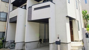 A multi-story building with a modern architectural design, featuring balconies and a visible entrance. - Sangen-jaya House-O (Tokyo)