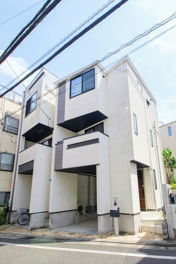 Un immeuble à plusieurs étages doté d’une architecture moderne, avec des balcons et une entrée bien visible.