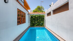 A swimming pool with a tiled edge, surrounded by white walls with a window and a wall-mounted light. - Great house with Pool S.Agustín By CanariasGetaway (Maspalomas)