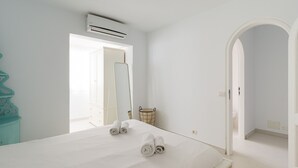 A hotel room with a bed, a large mirror, an air conditioning unit, and a wardrobe. - Great house with Pool S.Agustín By CanariasGetaway (Maspalomas)