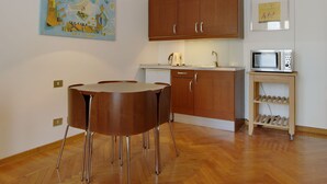 Eine moderne Küche mit Holzausstattung, einem runden Esstisch und einer Mikrowelle auf einer kleinen Ablagefläche.