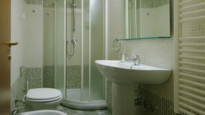 Ein Badezimmer mit Dusche, Toilette und Waschbecken.