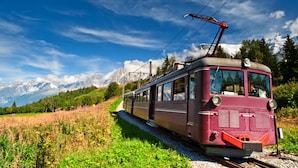 A vintage tram on tracks with a mountainous backdrop. - Apt Lachenal209A Central Chamonix Lift 3-min Walk, Chamonix, France (Chamonix)