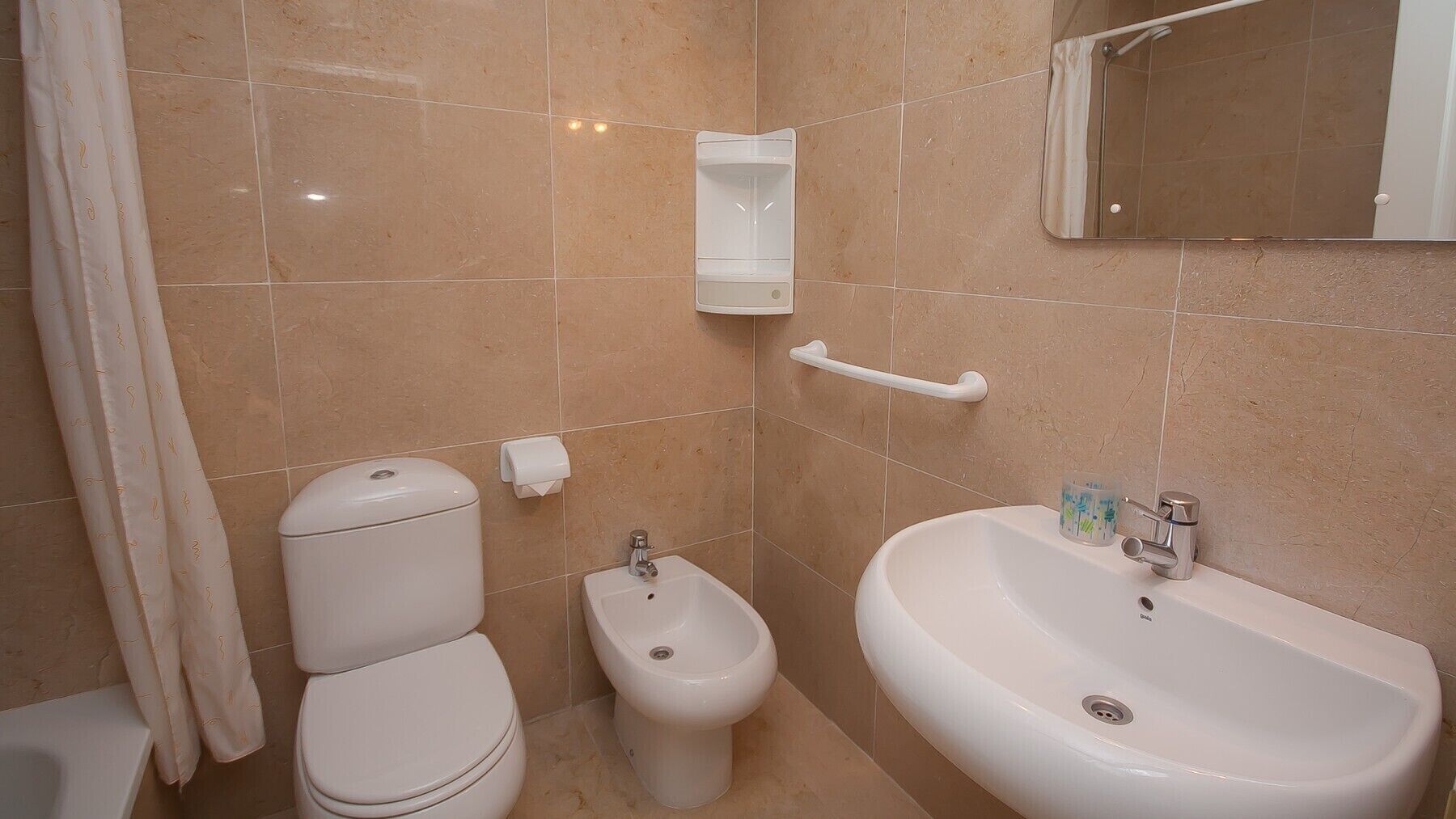 A bathroom with a toilet, bidet, and sink.