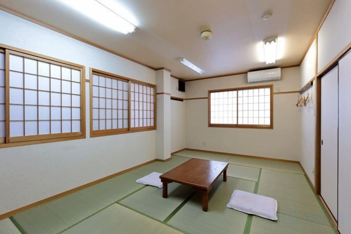 A traditional Japanese room with tatami flooring, a low wooden table, and shoji screens.