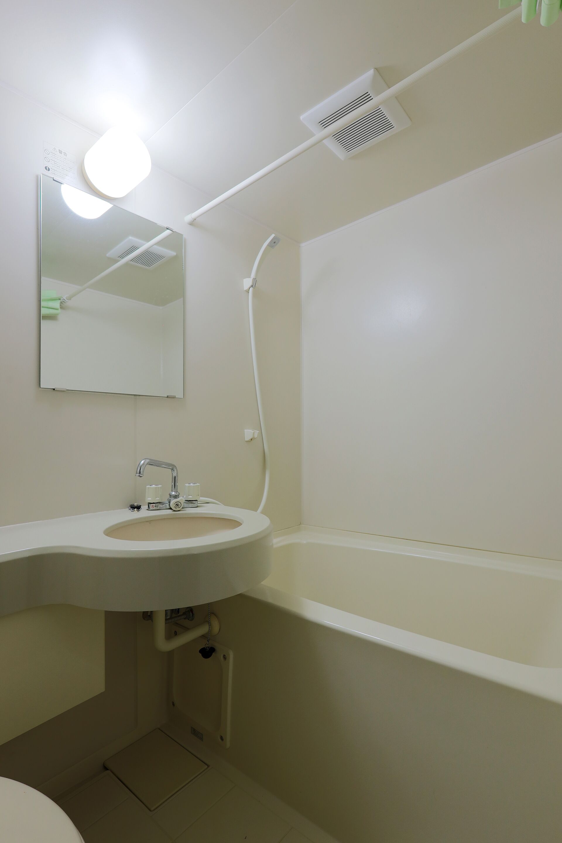 A bathroom with a sink, mirror, and shower.