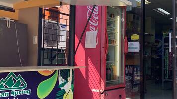 A colorful ice cream cart with a Coca-Cola logo, a Samsung refrigerator, and a sign for 'Green Spring Adaone'.