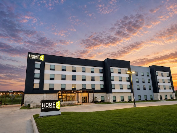 A modern hotel with a flat facade, multiple windows, and a sign indicating it is a Hilton property.