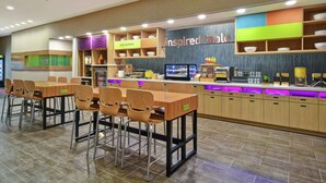 A restaurant with a counter, chairs, and shelves labeled with items like 'Good Morning' and 'Inspired Table'. - Home2 Suites by Hilton Wichita Northeast (Wichita)