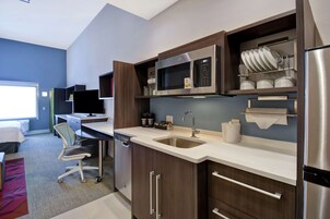 A modern kitchen with a microwave, sink, and stainless steel refrigerator.