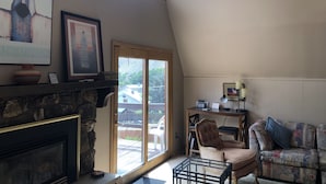 A cozy living room with a fireplace, a comfortable sofa, a chair, and a table. - High Desert Perch with views. (Farmington)