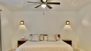 A bedroom with a bed, two nightstands, a ceiling fan, and wall-mounted lights. - Cactus House - Spacious home & pool next to mountains and close to everything (Phoenix)