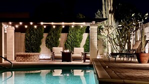 An outdoor pool area with a brick wall, green plants, and outdoor seating. - Cactus House - Spacious home & pool next to mountains and close to everything (Phoenix)