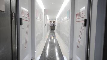 A corridor with doors labeled 'Motel 7' leading to a reception area.
