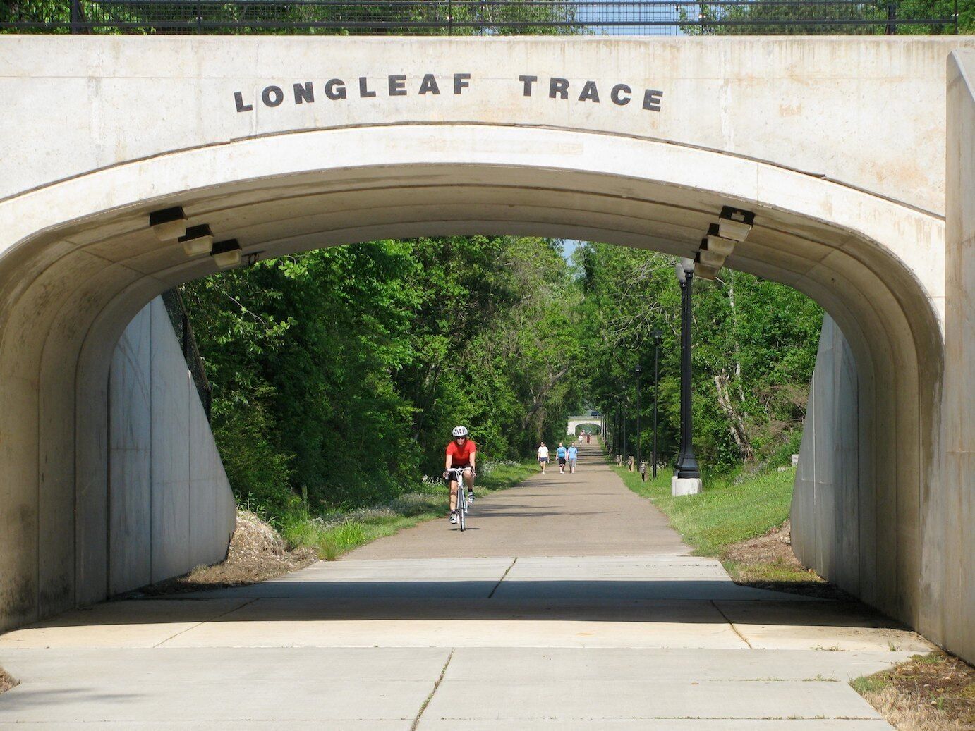 Un pont en béton portant l’inscription « LONGLEAF TRACE » et enjambant un sentier.
