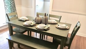 Une table à manger dressée avec des assiettes, des bols et un centre de table décoré.