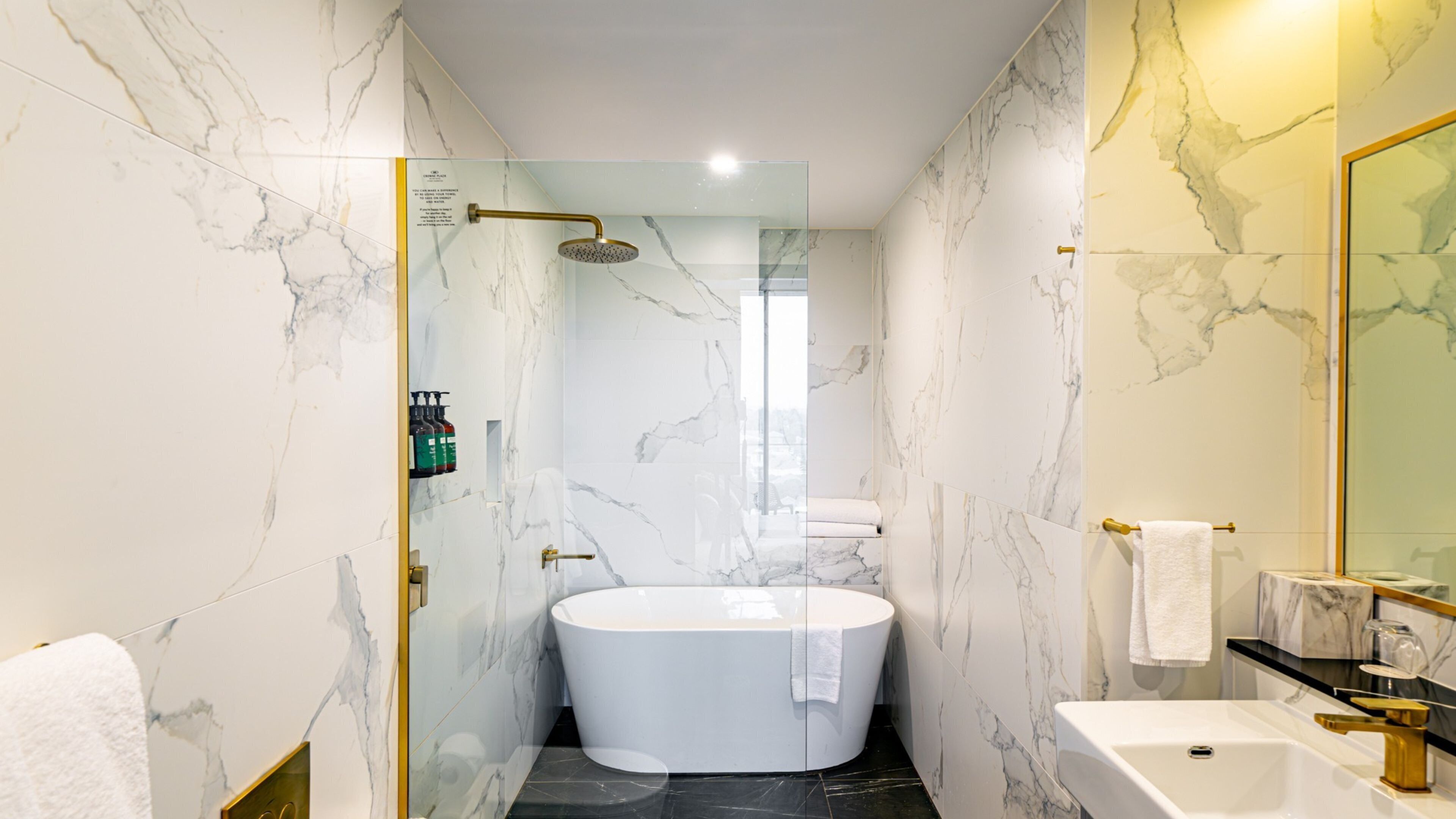 A modern bathroom with a freestanding bathtub, a glass-enclosed shower, and a vanity with a sink and mirror.