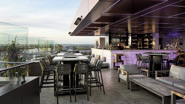 A rooftop bar with a panoramic city view, modern furniture, and a bar area with a wine display. - Crowne Plaza Sydney Burwood by IHG (Burwood)